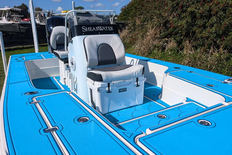 Slide: The Image of 2023 ShearWater X22 Hybrid boat with blue deck and Yeti cooler seat. - 16