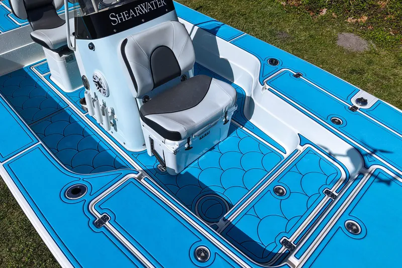 Slide: The Image of 2023 ShearWater X22 Hybrid boat interior with blue deck and seating. - 27