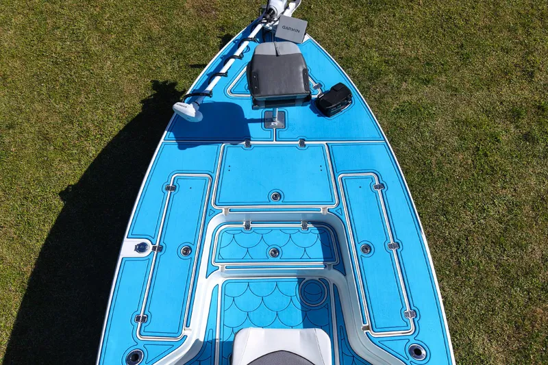 Slide: The Image of 2023 ShearWater X22 Hybrid boat deck with blue detailing on grass. - 29