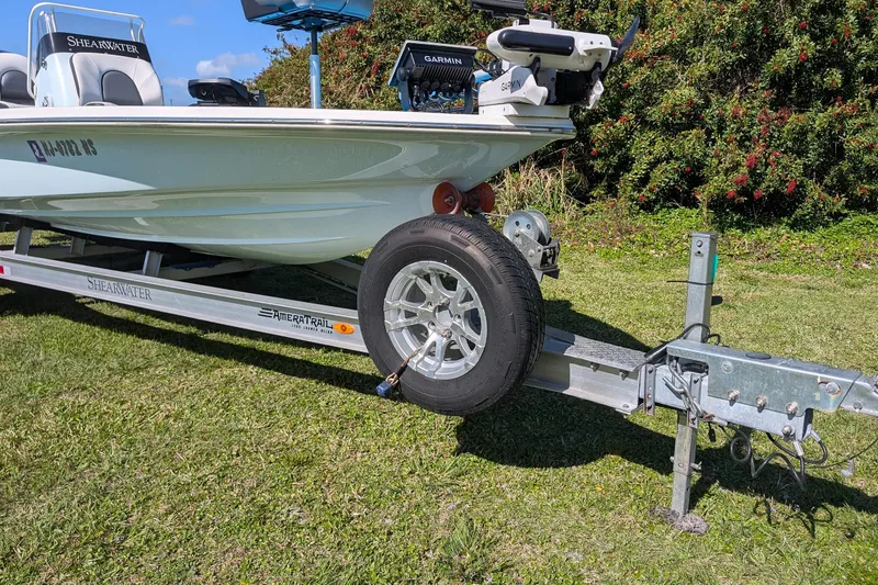 Slide: The Image of 2023 ShearWater X22 Hybrid boat on trailer, parked on grass. - 3