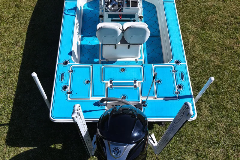 Slide: The Image of 2023 ShearWater X22 Hybrid boat with blue deck, viewed from above on grass. - 31