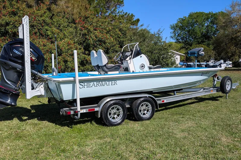 Slide: The Image of 2023 ShearWater X22 Hybrid boat on trailer, parked on grass. - 6