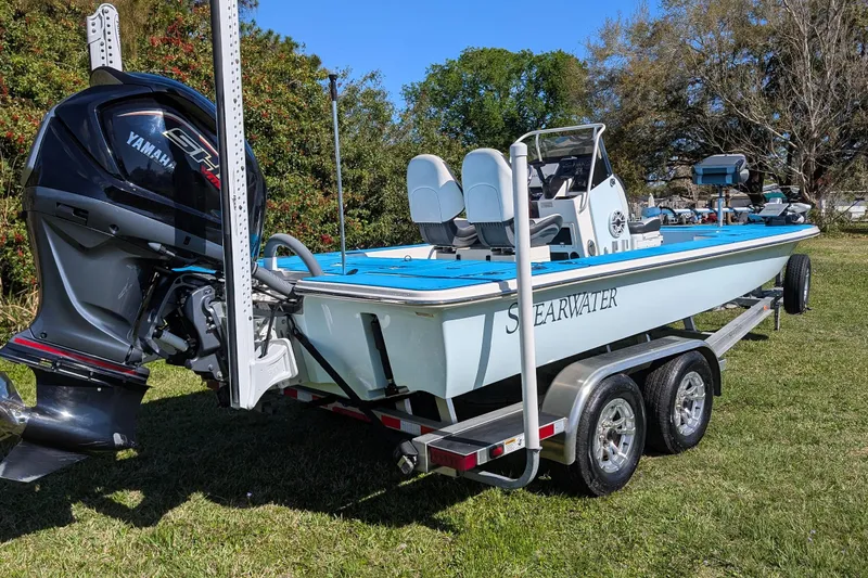 Slide: The Image of 2023 ShearWater X22 Hybrid boat on trailer with Yamaha engine, parked on grass. - 7