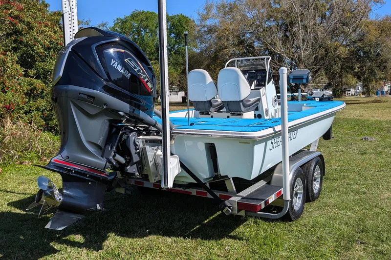 Slide: The Image of 2023 ShearWater X22 Hybrid boat with Yamaha engine on trailer, parked on grass. - 8