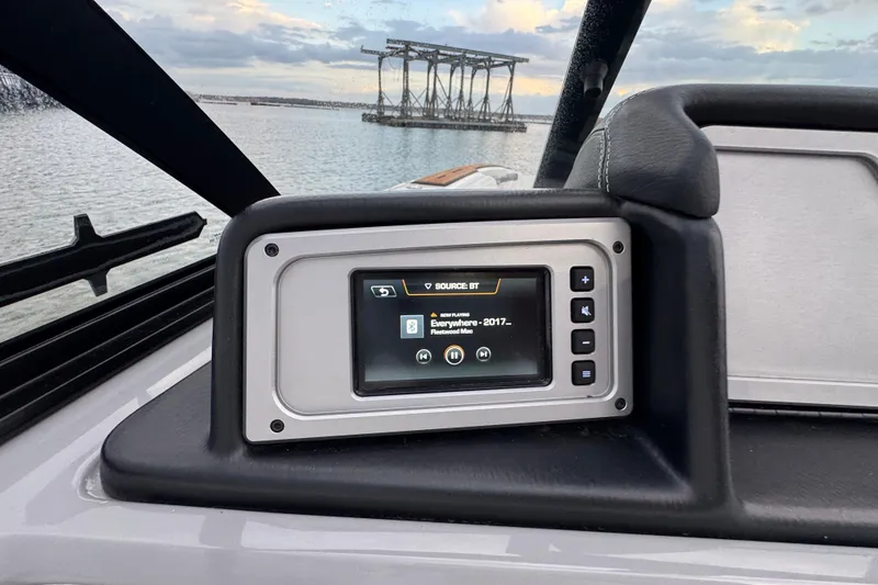 Slide: The Image of 2023 Supra SE 550 boat dashboard with digital display, lake view in background. - 22
