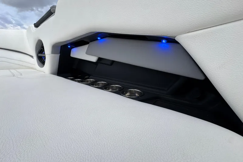 Slide: The Image of 2023 Supra SE 550 interior with white leather, cup holders, and blue LED lighting. - 25