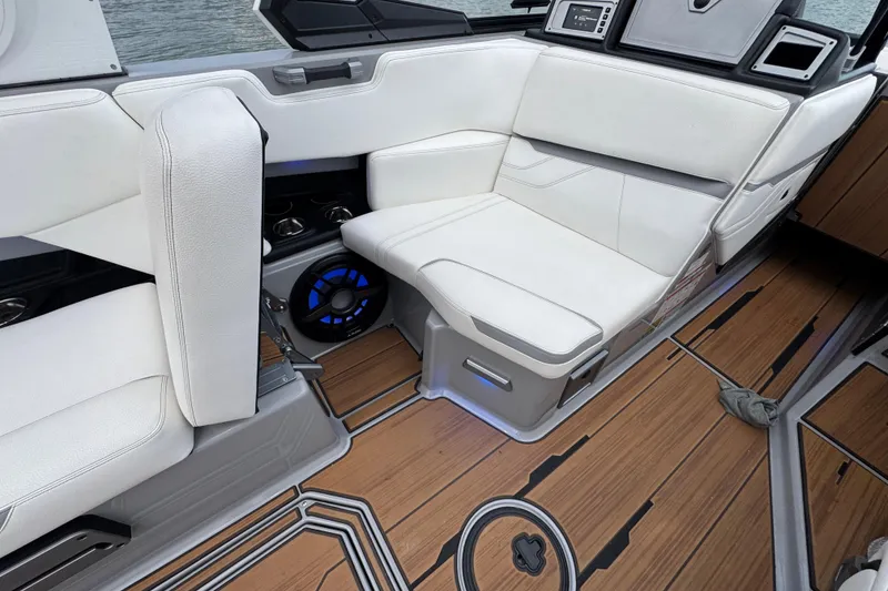 Slide: The Image of 2023 Supra SE 550 boat interior with white seating and wood-style flooring. - 26