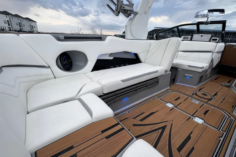 Slide: The Image of 2023 Supra SE 550 boat interior with white seating and wood flooring. - 27
