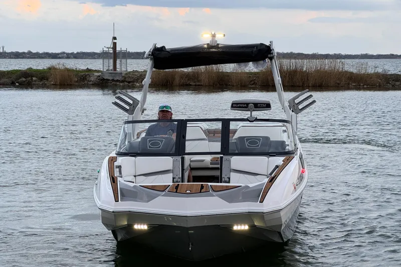 Slide: The Image of 2023 Supra SE 550 boat on water, front view with driver, overcast sky. - 3