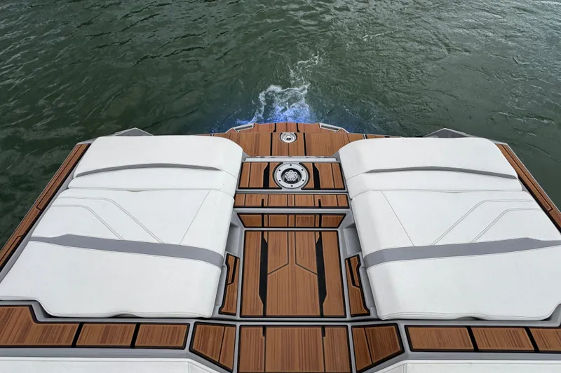 Slide: The Image of 2023 Supra SE 550 boat deck with cushioned seating and teak flooring on water. - 30