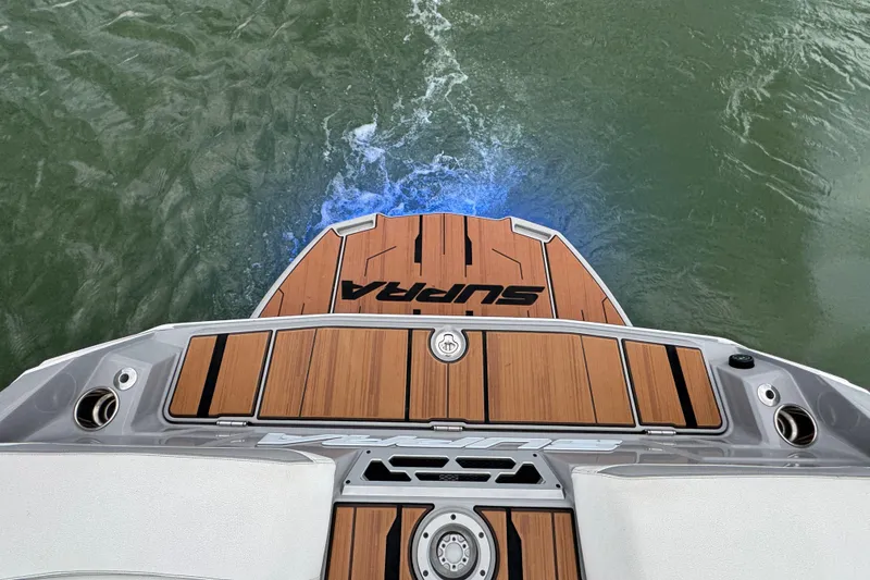 Slide: The Image of 2023 Supra SE 550 boat deck with teak finish on water. - 31