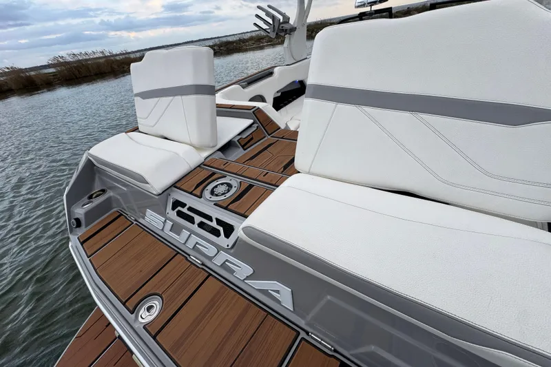 Slide: The Image of 2023 Supra SE 550 boat interior with white seats and wooden deck. - 32