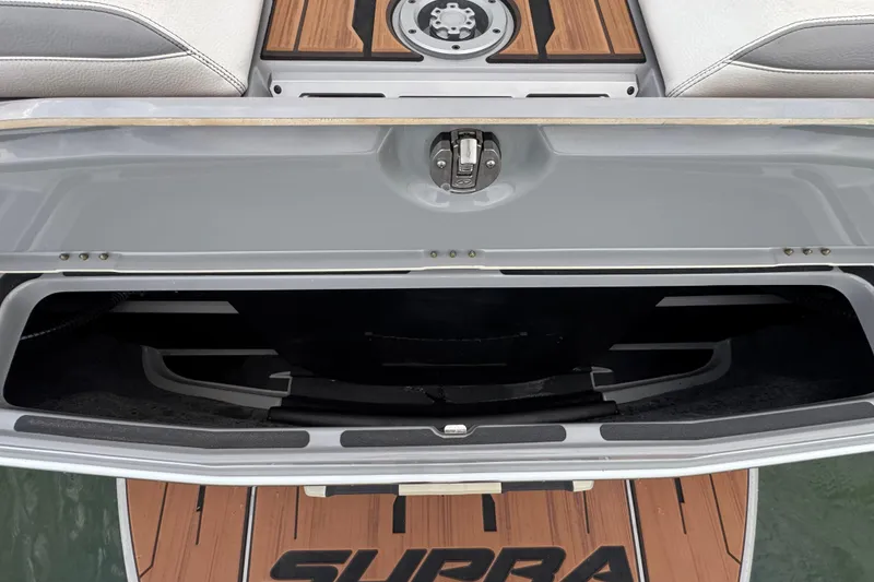 Slide: The Image of 2023 Supra SE 550 boat storage compartment with wood accents and sleek design. - 34