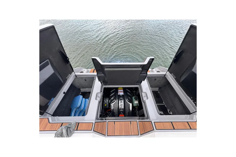 Slide: The Image of 2023 Supra SE 550 boat engine compartment with open storage hatches on water. - 36