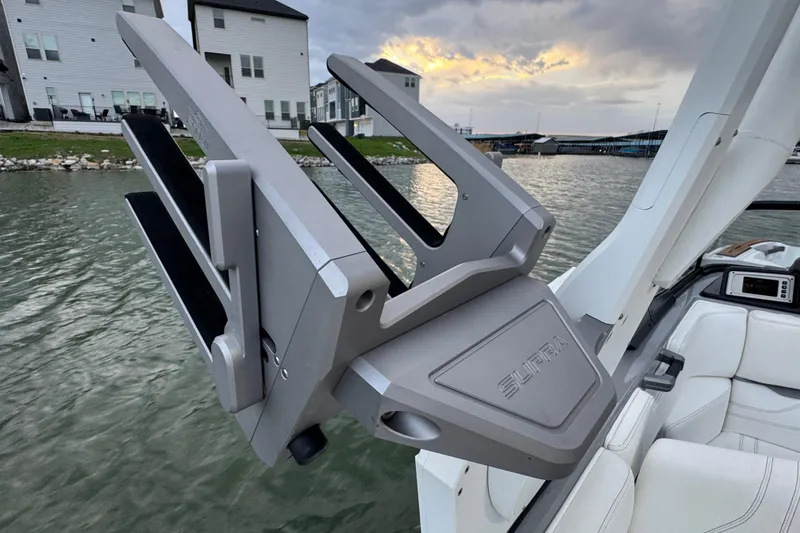 Slide: The Image of 2023 Supra SE 550 boat with advanced wakeboard rack on a serene lake. - 39
