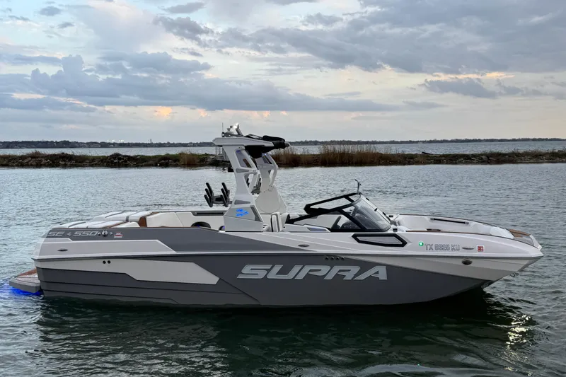 Slide: The Image of 2023 Supra SE 550 boat on water, under a cloudy sky. - 5
