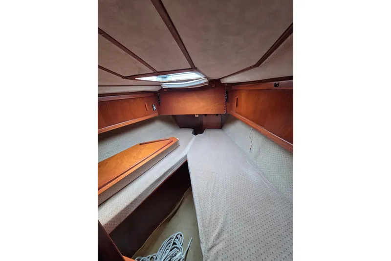 Slide: The Image of Interior cabin of 1988 Amel Sharki sailboat with wooden finish and cozy bedding. - 11