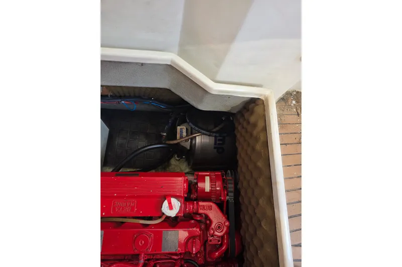 Slide: The Image of Engine compartment of 1988 Amel Sharki sailboat with red machinery and insulation. - 14
