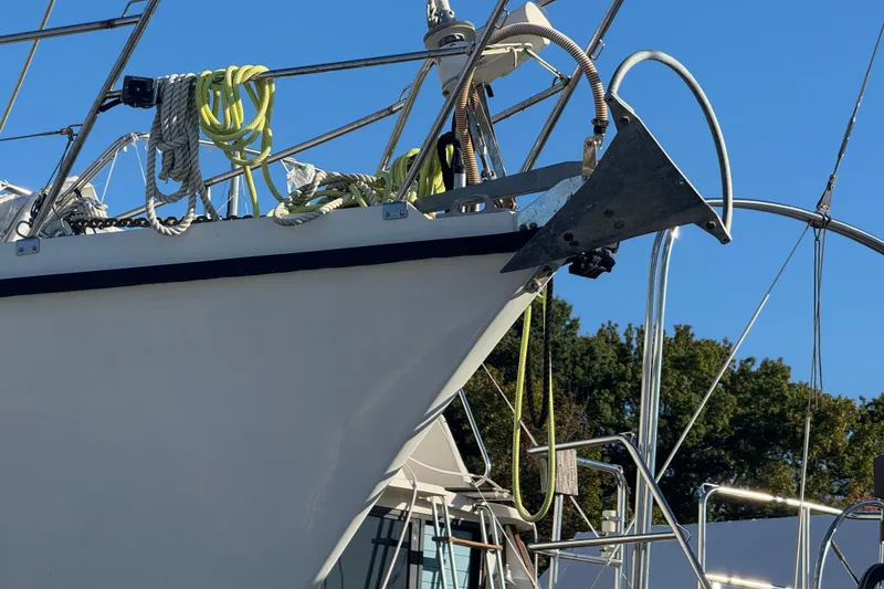 Slide: The Image of Bow of 1988 Amel Sharki sailboat with anchor and ropes, clear blue sky background. - 4