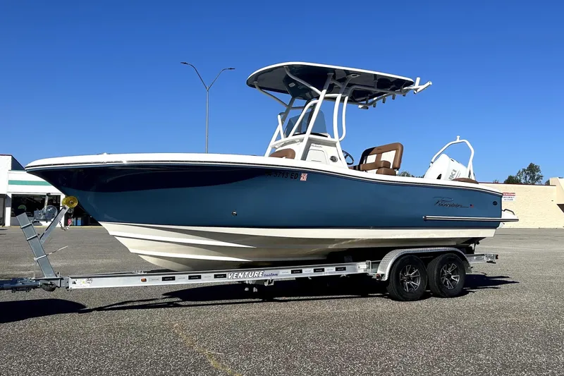 The Image of 2023 Pioneer 222 Islander boat on trailer in parking lot under clear blue sky. - 0