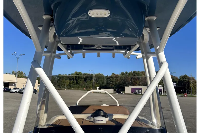 Slide: The Image of 2023 Pioneer 222 Islander boat with T-top and electronics, parked outdoors. - 18