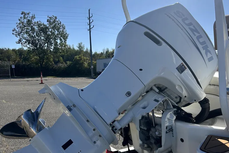 Slide: The Image of 2023 Pioneer 222 Islander with Suzuki outboard motor in a parking lot. - 19