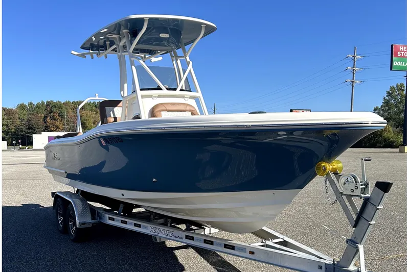 Slide: The Image of 2023 Pioneer 222 Islander boat on trailer, blue hull, sunny day. - 2