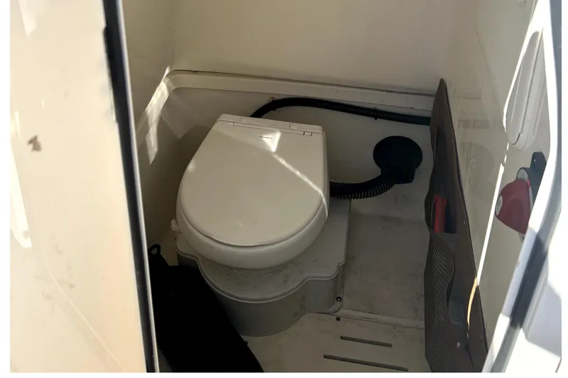 Slide: The Image of 2023 Pioneer 222 Islander boat interior with compact marine toilet. - 21