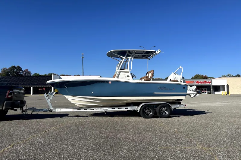 Slide: The Image of 2023 Pioneer 222 Islander boat on trailer in parking lot, clear blue sky background. - 4
