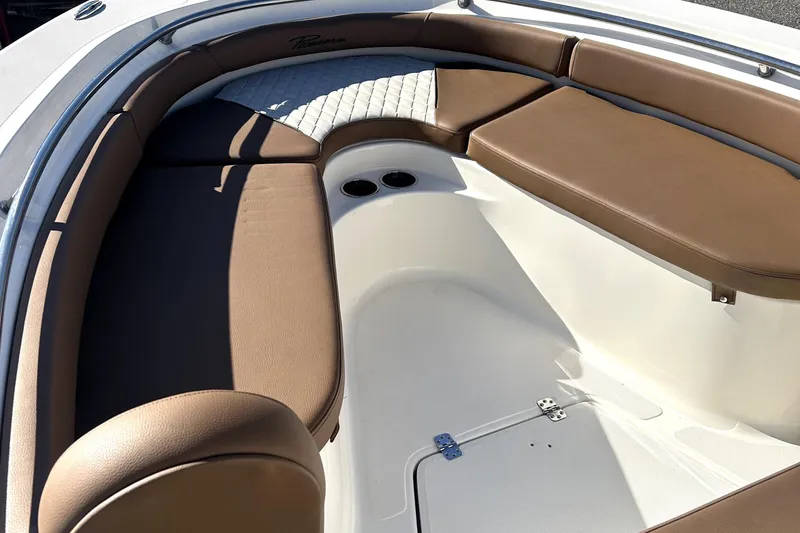 Slide: The Image of 2023 Pioneer 222 Islander boat interior with brown cushioned seating and cup holders. - 7