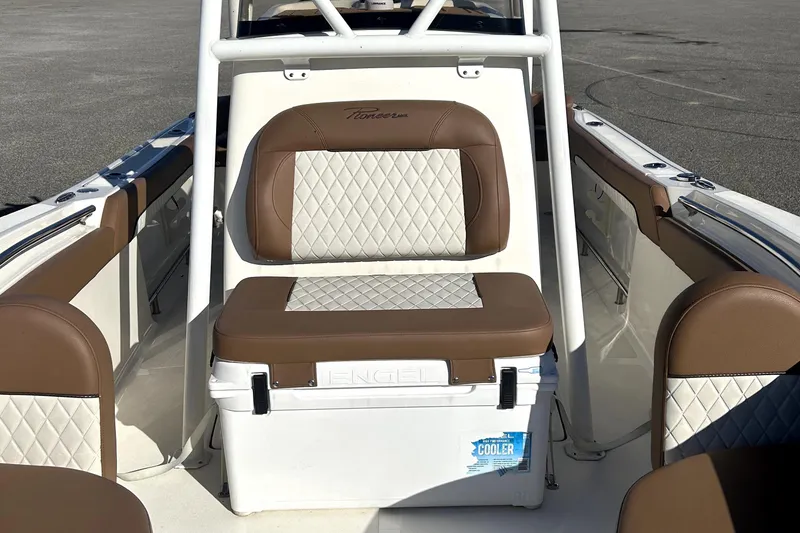 Slide: The Image of 2023 Pioneer 222 Islander boat interior with brown and white cushioned seating. - 8