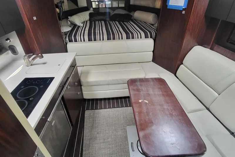 Slide: The Image of 2016 Monterey 335 Sport Yacht interior with kitchenette, seating, and bed. - 19