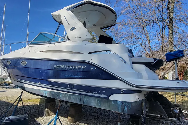 Slide: The Image of 2016 Monterey 335 Sport Yacht on stands, blue and white exterior, parked outdoors. - 4