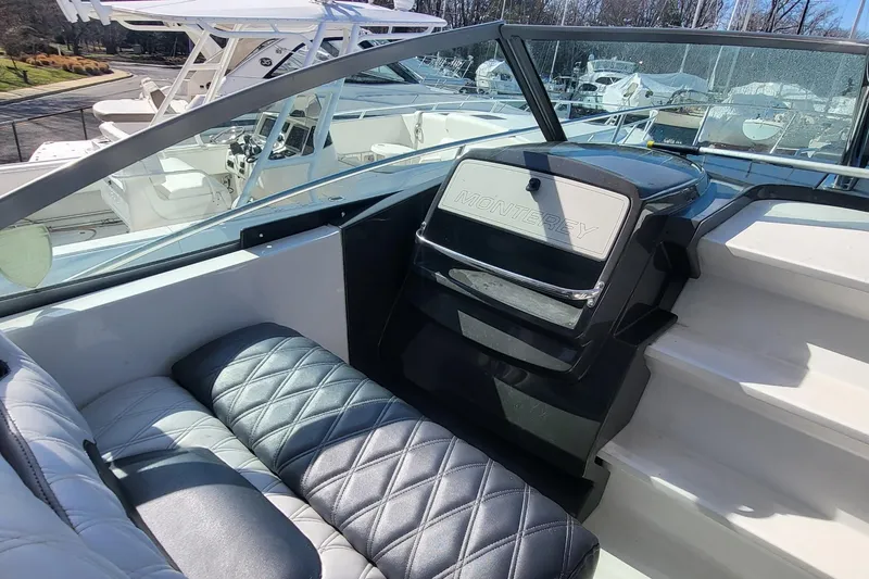 Slide: The Image of 2016 Monterey 335 Sport Yacht interior with quilted seating and dashboard view. - 8