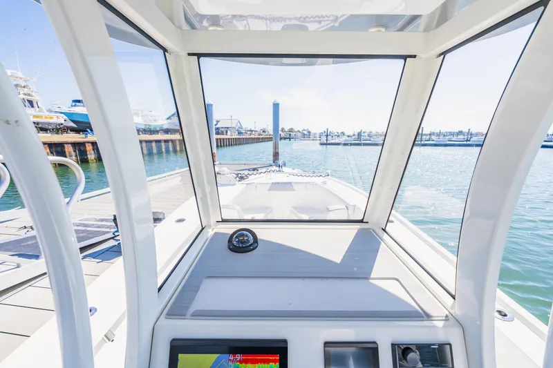 Slide: The Image of Interior view of a 2023 Parker 2400 boat cockpit, overlooking a marina. - 13