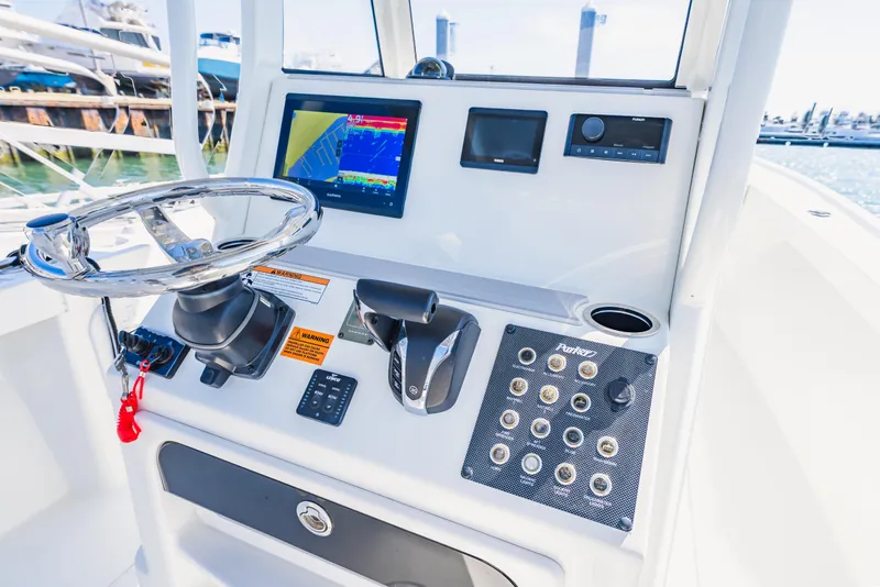 Slide: The Image of Control panel of a 2023 Parker 2400 boat with steering wheel and navigation display. - 19