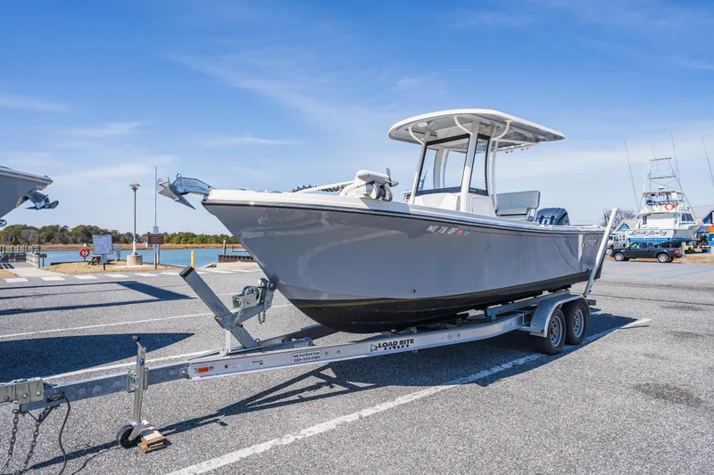 Slide: The Image of 2023 Parker 2400 boat on trailer at marina, clear sky background. - 23