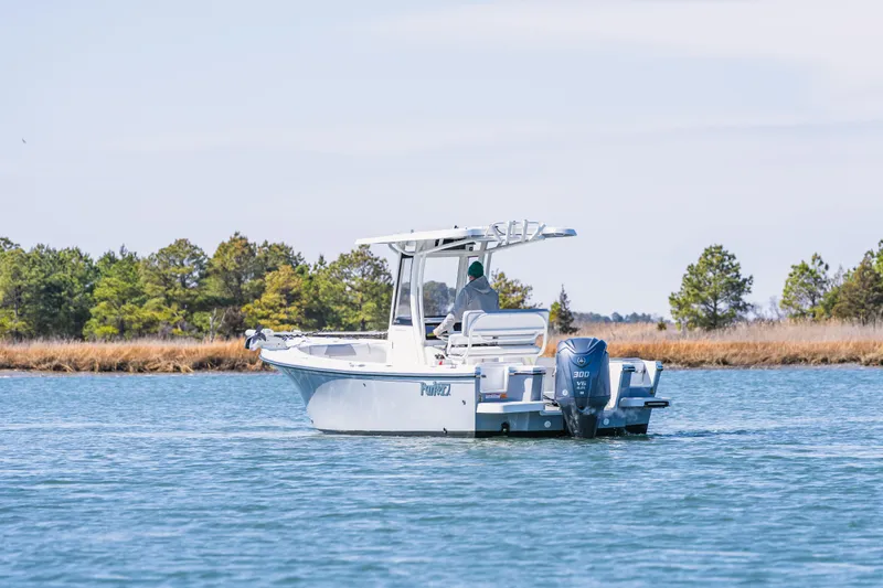 Slide: The Image of 2023 Parker 2400 boat cruising on a calm lake with trees in the background. - 3