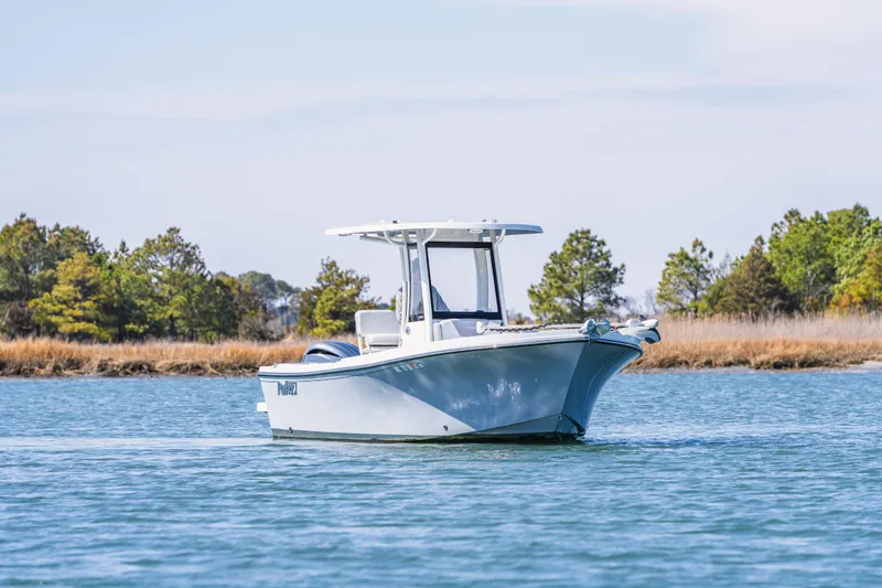 Slide: The Image of 2023 Parker 2400 boat cruising on a serene lake with trees in the background. - 5
