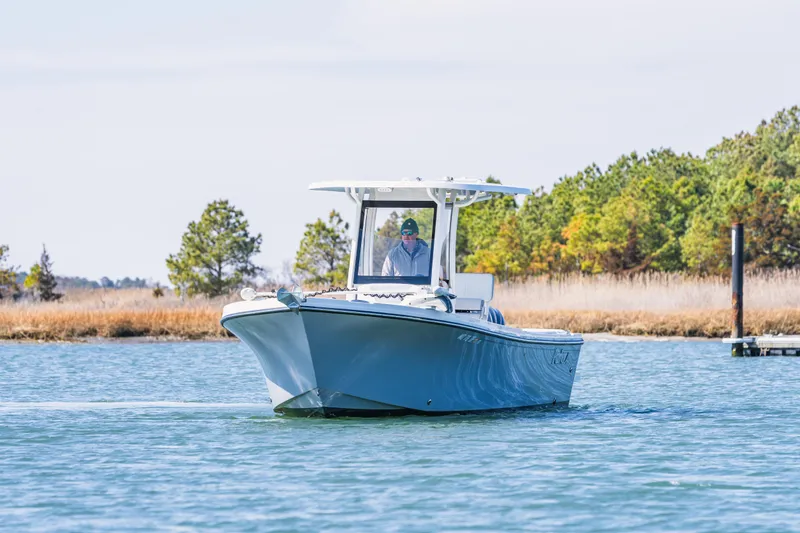 Slide: The Image of 2023 Parker 2400 boat cruising on a serene lake with trees in the background. - 7