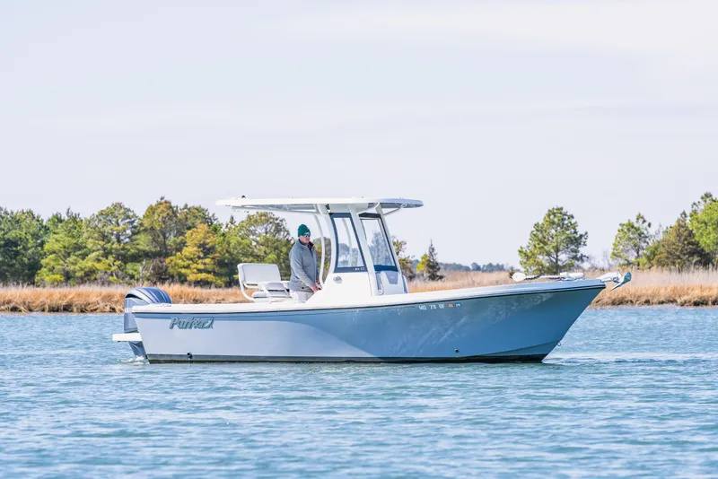 The Image of 2023 Parker 2400 boat cruising on a calm lake with trees in the background. - 0