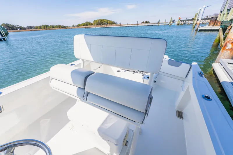 Slide: The Image of 2023 Parker 2400 boat interior with white seating, docked by calm waters. - 10