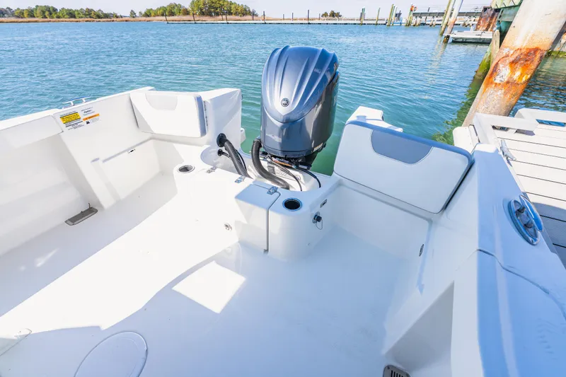 Slide: The Image of 2023 Parker 2400 boat with outboard motor, docked on calm water. - 12