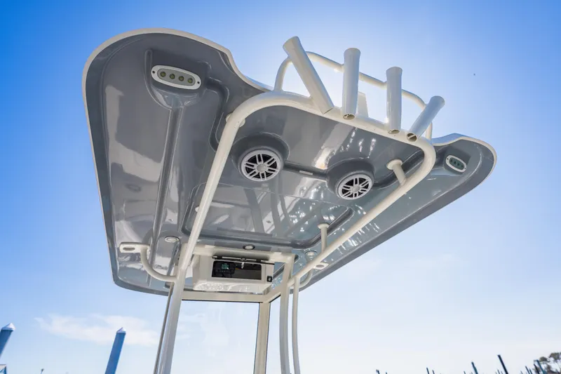 Slide: The Image of Parker 2400 boat canopy with speakers and rod holders, 2023 model, under clear blue sky. - 18