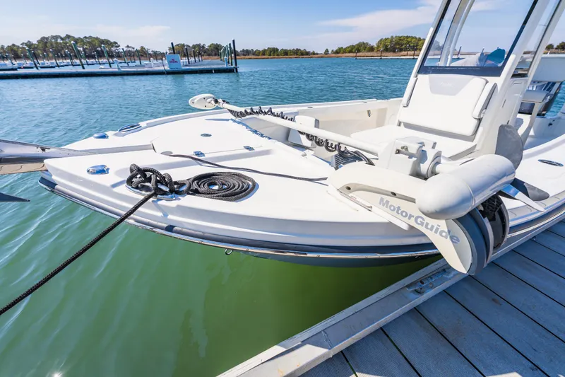 Slide: The Image of 2023 Parker 2400 boat docked with MotorGuide trolling motor, calm waters in the background. - 21