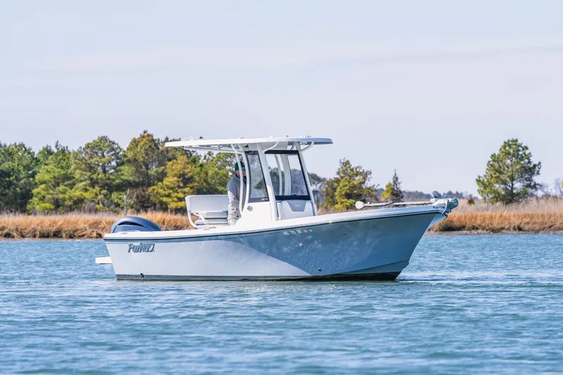 Slide: The Image of 2023 Parker 2400 boat cruising on a serene lake with trees in the background. - 4