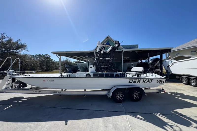The Image of 2023 Dek Kat 27 Trilogy boat on trailer under clear blue sky. - 1