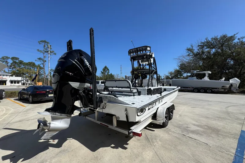 Slide: The Image of 2023 Dek Kat 27 Trilogy boat with Mercury engine on trailer in sunny outdoor setting. - 11