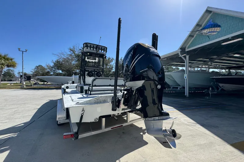 Slide: The Image of 2023 Dek Kat 27 Trilogy boat with powerful Mercury engine, parked outdoors. - 13