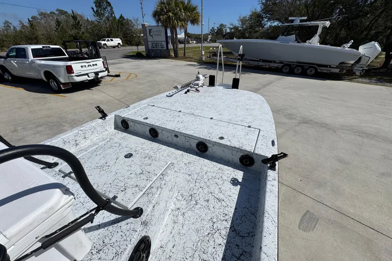 Slide: The Image of 2023 Dek Kat 27 Trilogy boat on trailer, parked near white Ram truck. - 16
